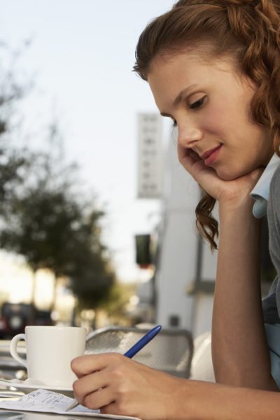 Woman writing a financial plan or a budget.
